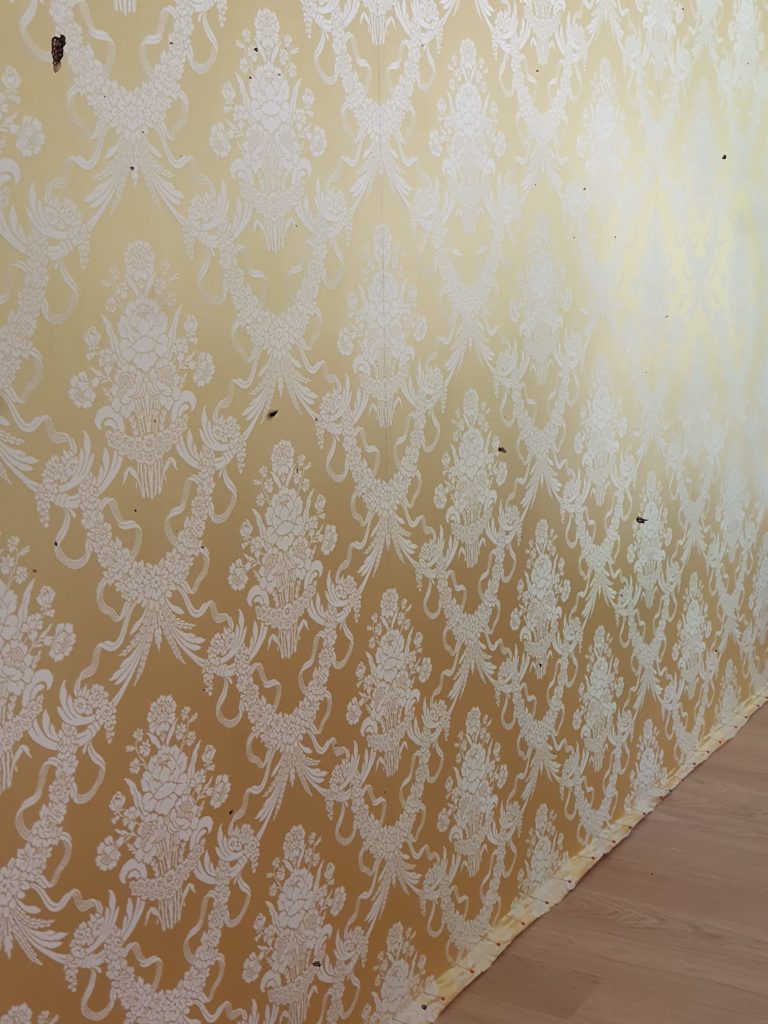 Tenture murale en damassé de soie, avec des motifs délicats et une texture riche, ajoutant une touche de luxe à l'intérieur.