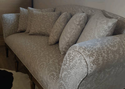 Sofa restauré avec un tissu jacquard beige texturé et ses coussins assortis réalisés sur mesure.