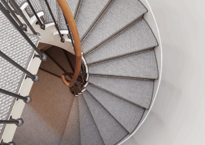 Escalier recouvert de sisal naturel avec tiges de maintien, finition professionnelle sur mesure.